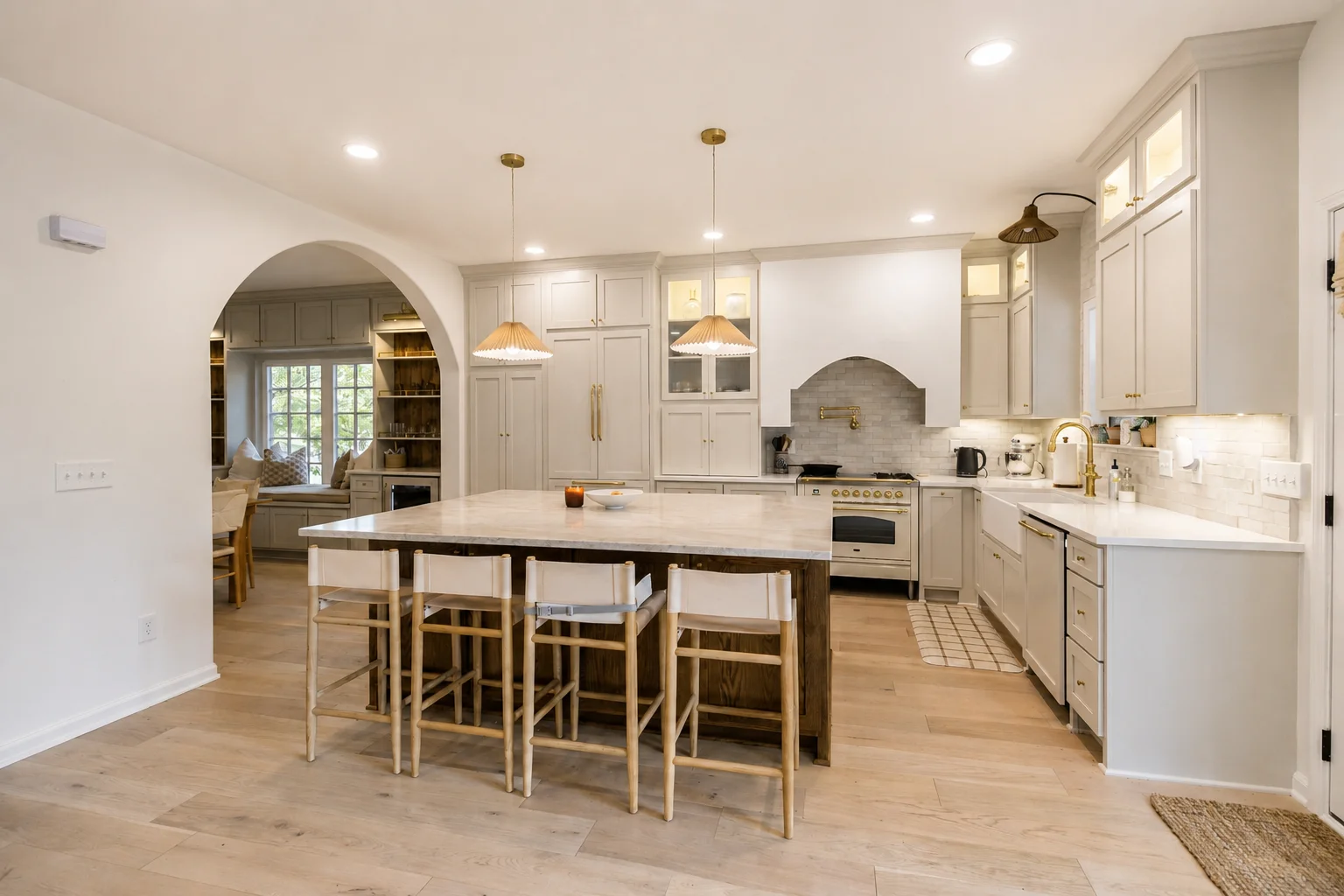 Warm kitchen with natural wood, white cabinetry, and an arched opening — edited project photograph